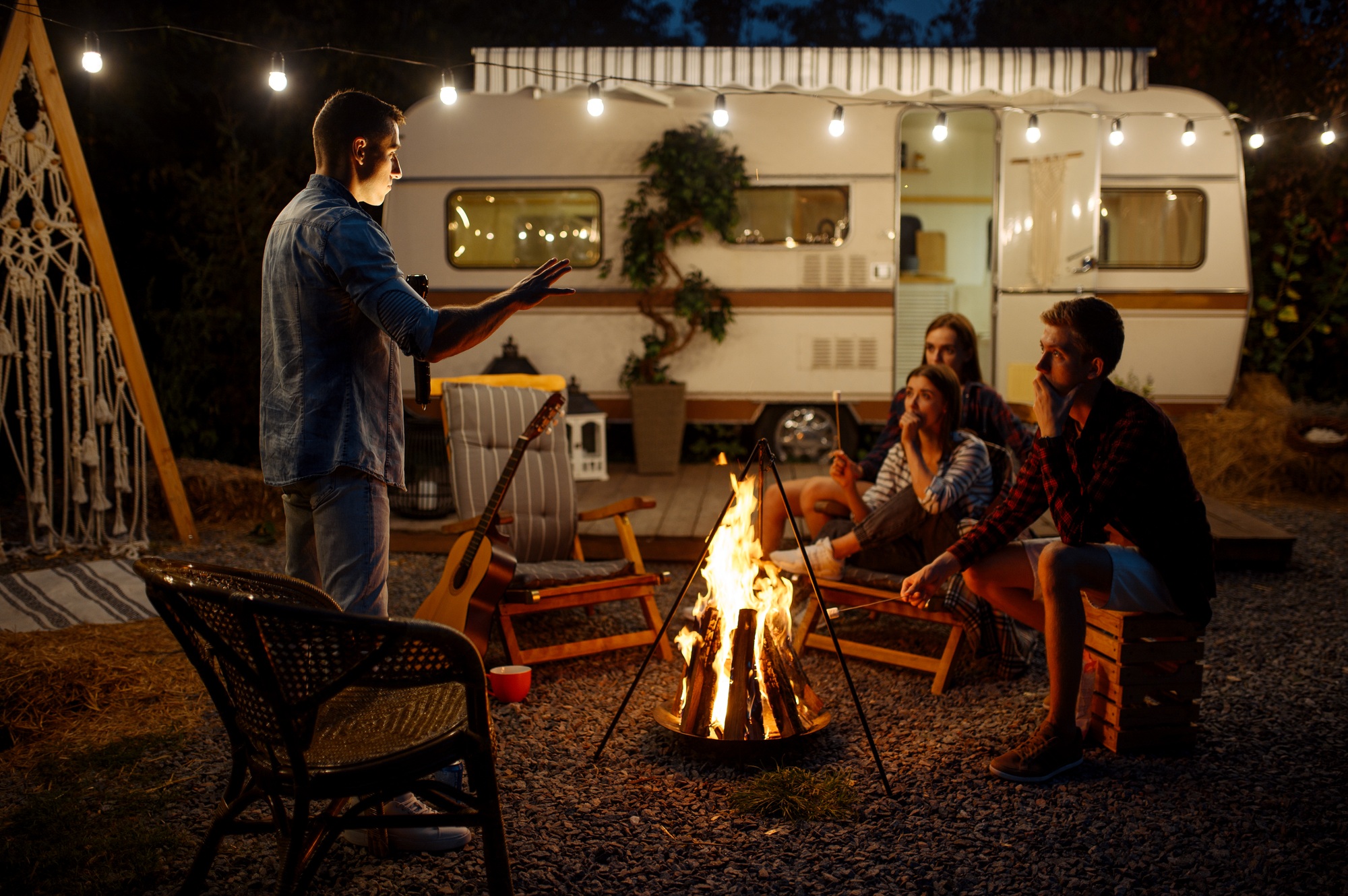 Man tells a scary story by the bonfire, camping